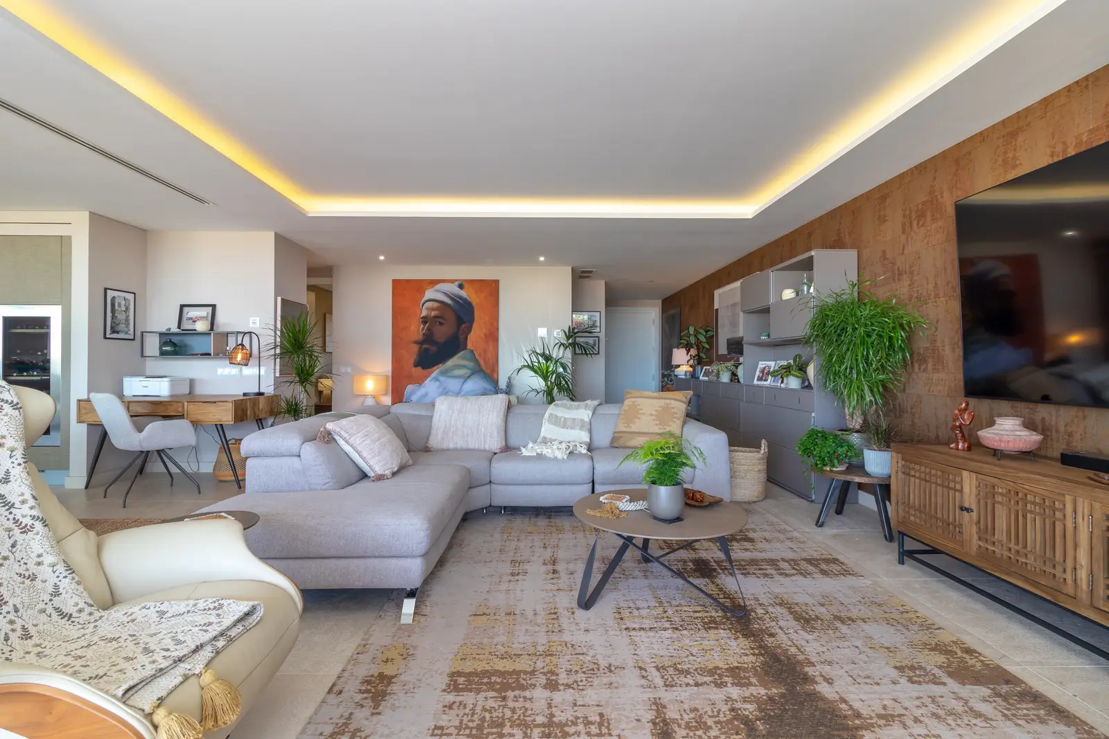 Living room sofa with portrait painting and the dining area visible beyond