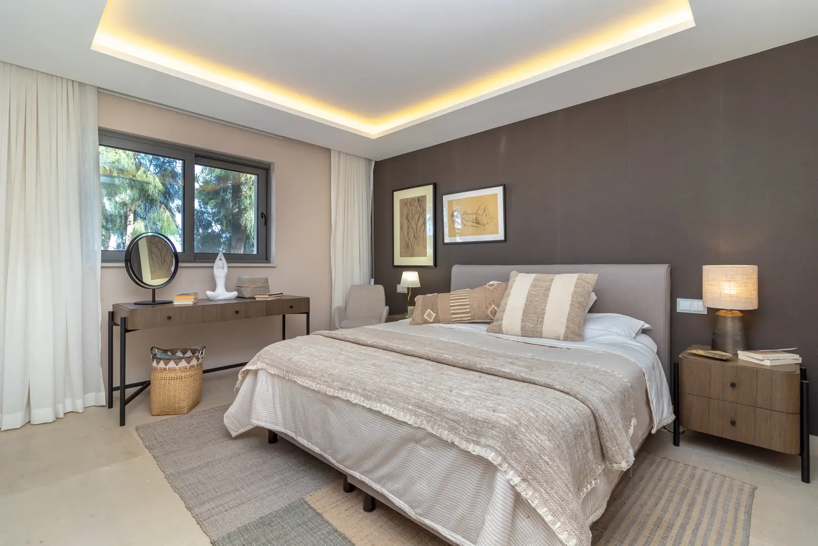 Double bedroom with upholstered headboard, dark feature wall, dressing table and cove lighting