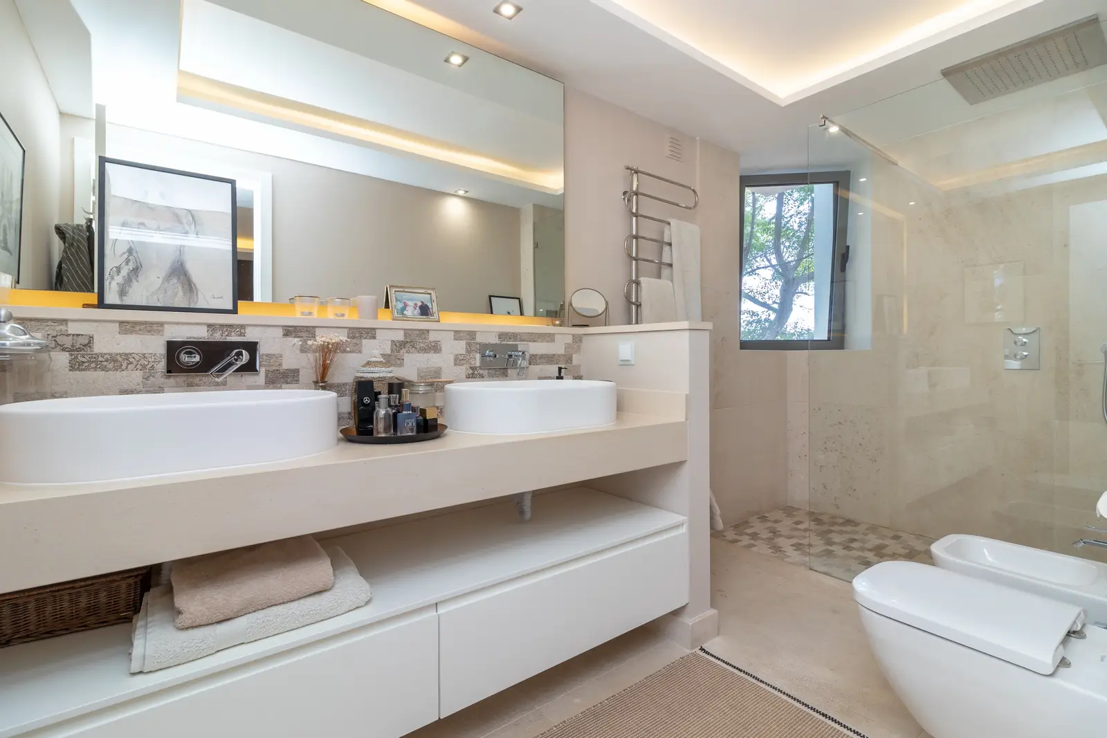 En-suite bathroom with twin basins, mirrored wall, walk-in shower and bidet