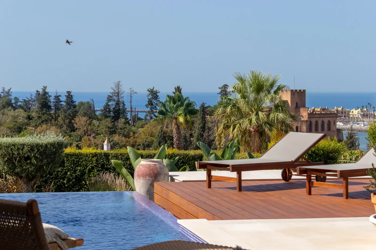 Loungers on the sun deck with the Ferragudo castle and the sea in the distance