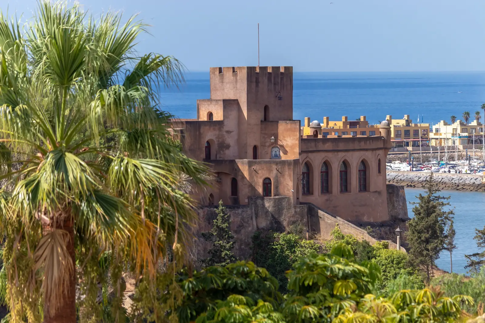 Castelo de Sao Joao de Arade and the marina seen from the terrace across palm trees