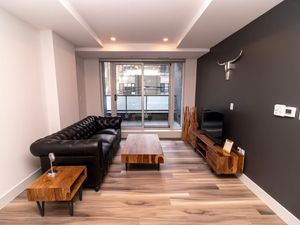 Unwind in the stylish living room with expansive skyline views. Settle into the cozy seating and enjoy your favorite shows on the Smart TV.