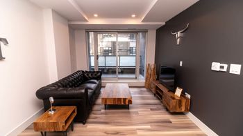 Unwind in the stylish living room with expansive skyline views. Settle into the cozy seating and enjoy your favorite shows on the Smart TV.