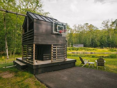 Playhouse with swing and basketball hoop, (guest house in background)