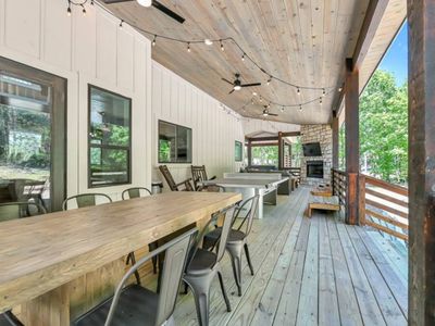 Outside on the covered patio there is a large dining table, seating 8.