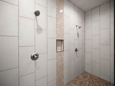 Huge walk-in shower with multiple shower heads.