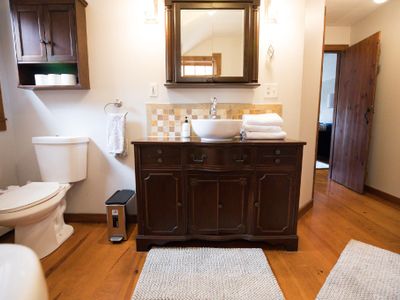 The master bathroom features a rustic vanity, soaking tub and walk in shower.