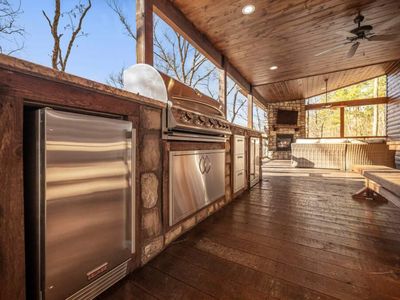 Built-in outdoor kitchen with sink, gas grill, ice maker, and mini fridge