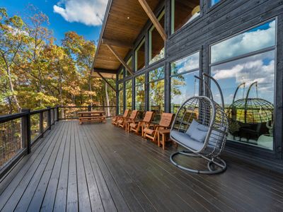 Spacious terrace with comfy swing, chairs and dining area.