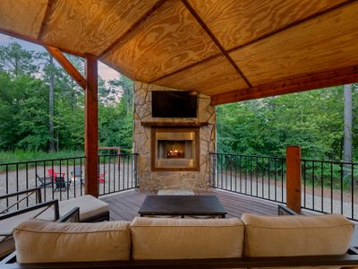 The covered outdoor patio on the main level. Outdoor seating around a fireplace.