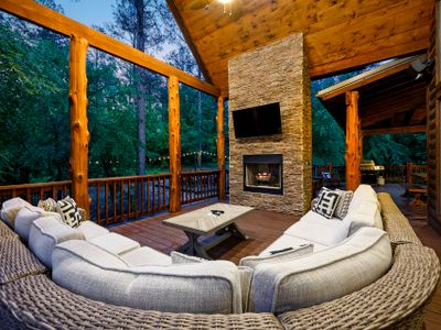 The covered patio has an oversized sectional around the fireplace.
