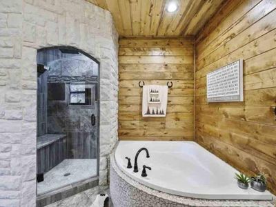 In-suite bathroom with a soaking tub and a stone walk-in shower.