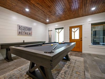 Equipped with a pool table, shuffleboard and outdoor patio access.