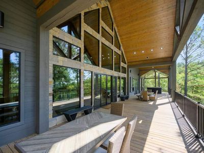 The wrap around porch has dining tables, a kitchen, couches and more!