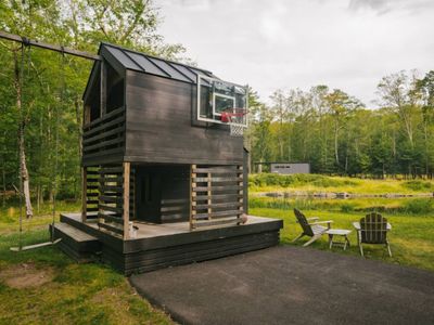 Playhouse with swing and basketball hoop, (guest house in background)
