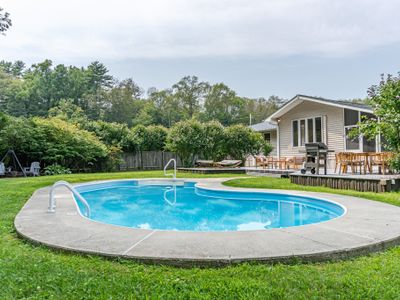 Private and fenced-in, with a tree-lined backdrop that creates a mesmerizing symphony on a windy day—perfect for relaxing on a float.