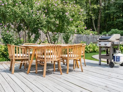 Calling all grill enthusiasts! Serve up a delicious feast for your guests while enjoying views of the in-ground pool and serene wooded backyard.