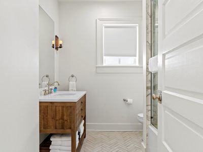 First bathroom with spacious shower and large mirror provided
