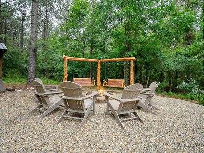 Fire pit surrounded by Adirondack chairs.