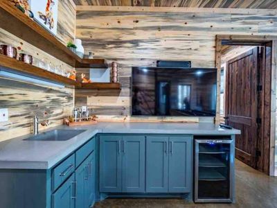 Closer look at the wet bar equipped with counter space, smart tv and mini fridge