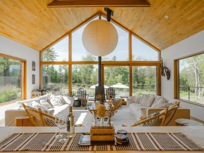 the open concept kitchen and beautiful main living room that looks out over the deck