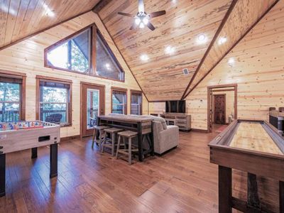 The loft features a foosball table, a sleeper sofa and shuffleboard table.