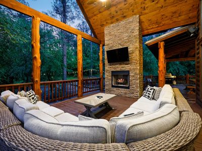 The covered patio has an oversized sectional around the fireplace.