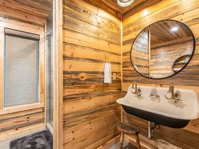 The private bathroom featuring a trough sink and walk-in shower.