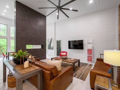 The open-concept living room with luxury couches situated around the tcv.