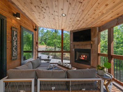 An oversized sectional placed around the outdoor fireplace and tv.