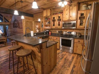The kitchen has updated appliances and a bar top for additional seating.