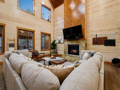 The main living area has an oversized sectional around the fireplace and tv.