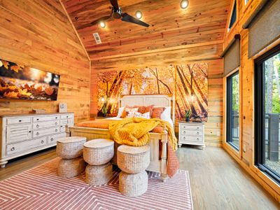 Warm hues, leafy art, and cozy textures make this room feel like a luxury cabin in peak fall.