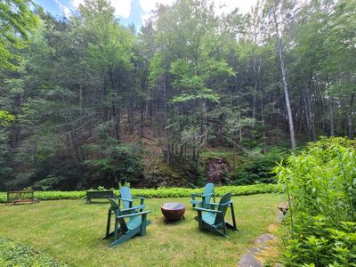 Kick back at the new firepit and Adirondack chairs with view of  the creek .