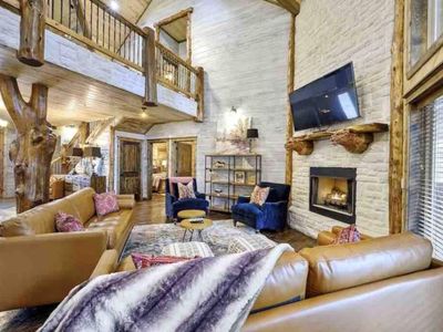 A gathering space with high-end couches surrounding the indoor gas fireplace.