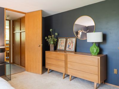 Storage space across the bed, topped with Egyptian art.