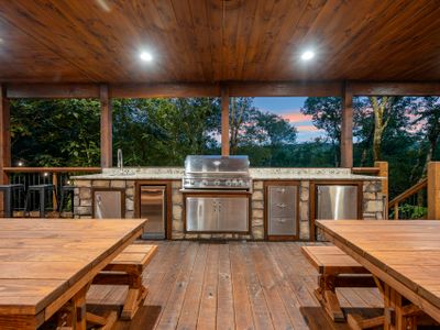 Built-in outdoor kitchen with sink, gas grill, ice maker, and mini fridge