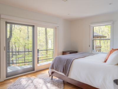 Stepping into the first of the main floor bedrooms, with access to the sprawling deck.