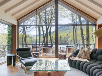 Massive windows in the living room reveal breathtaking views of the Shawangunks and private lake below.