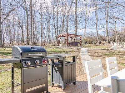 The Weber grill with the hot tub and fire pit in the background.