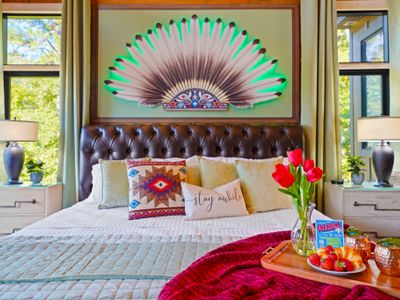 The illuminated headdress art above the bed adds a mesmerizing glow to this stunning themed sanctuary.