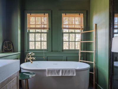 The green bathroom off the kitchen is complete with a beautiful bath tub, walk-in shower, and brass fixtures throughout.