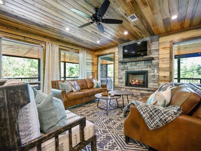 The living room with matching sofas and lounge seating around the fireplace.