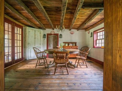 Dining room off of living area and kitchen with old wood beams