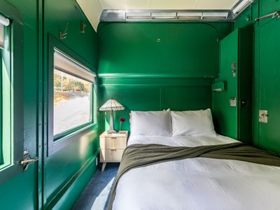 The Adirondack Suite equipped with a closet, bedside table, robes and slippers.