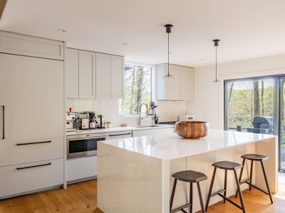 This spacious kitchen features an expansive island and sliding doors leading to the grill and outdoor dining area.