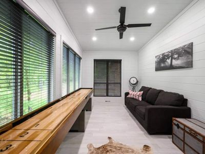 A game room featuring shuffleboard as well as a sleeper sofa.