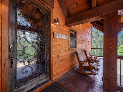 The front porch is accompanied by rocking chairs.