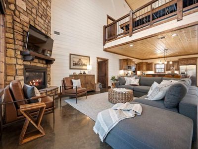 An oversized sectional placed around the floor to ceiling fireplace.