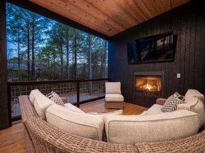 The outdoor covered patio, an oversized sectional around the fireplace.